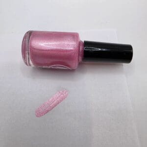 Pink nail polish bottle with swatch.