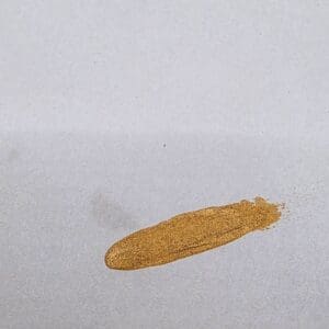 Gold paint smear on white paper.