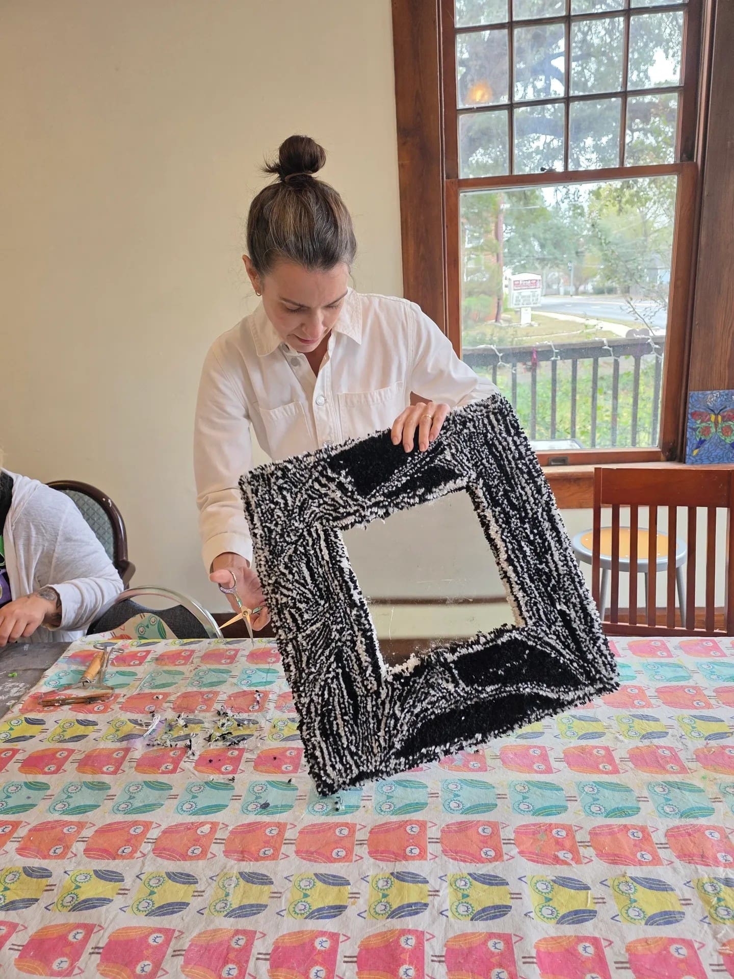 Person holding a decorated framed mirror.