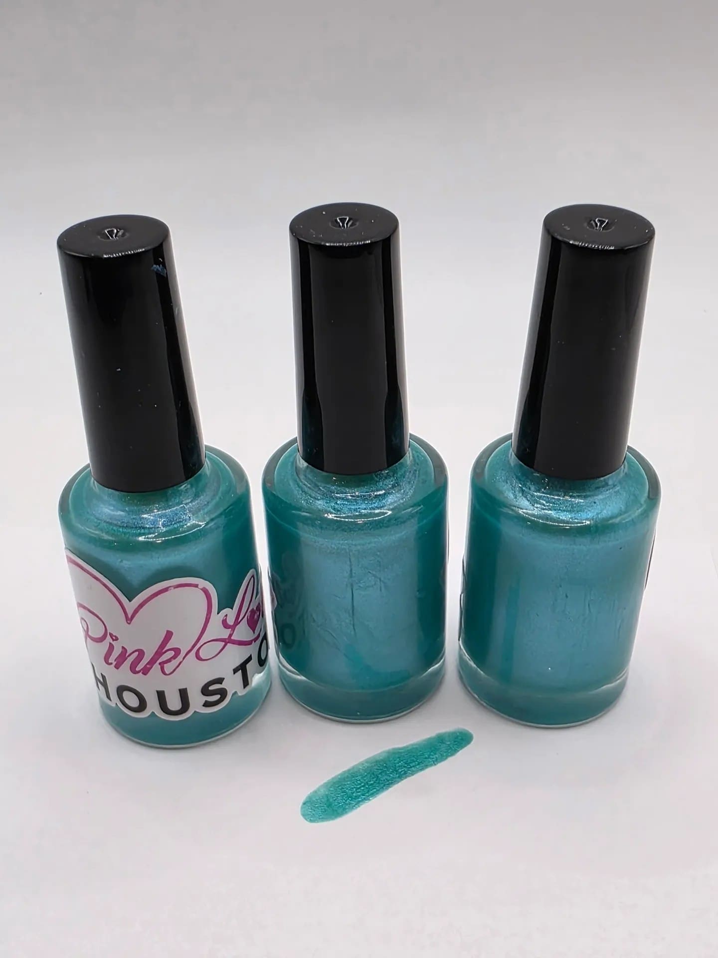 Three bottles of turquoise nail polish.