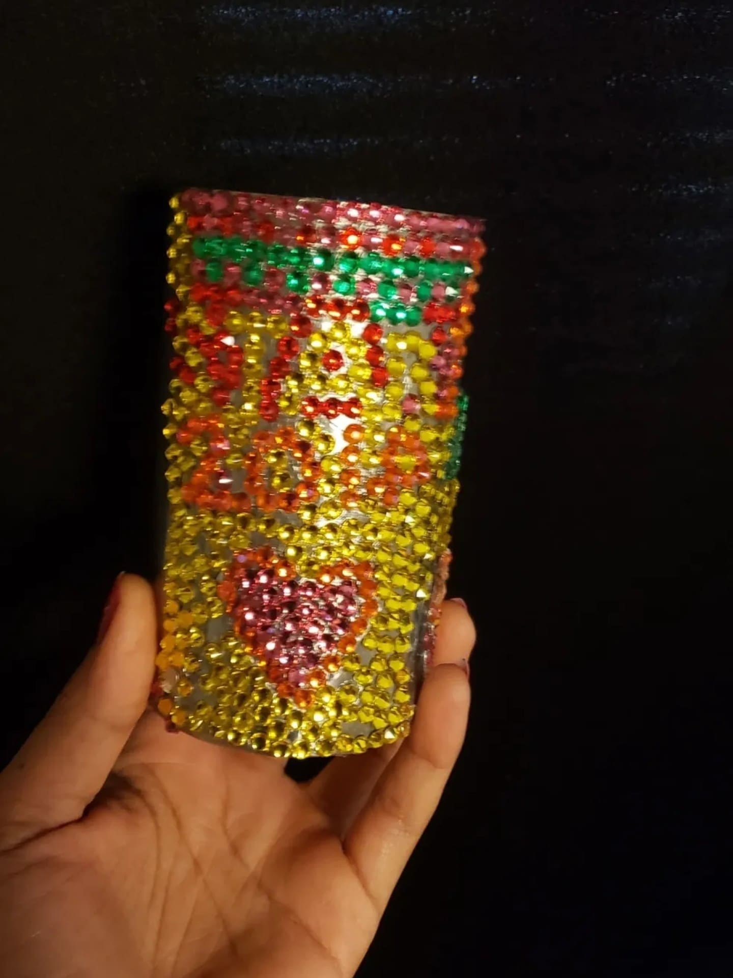 Colorful beaded cup with heart design.